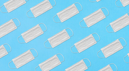 medicine, healthcare and safety concept - diagonal pattern with white medical mask on blue background