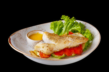 Halibut steak with vegetables isolated on black