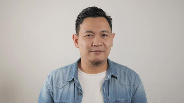 Young happy successful Asian man smiling at camera. Confident good looking positive person