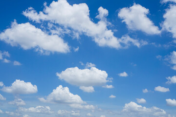 Naklejka na ściany i meble Beautiful white fluffy clouds on vivid blue sky in a suny day