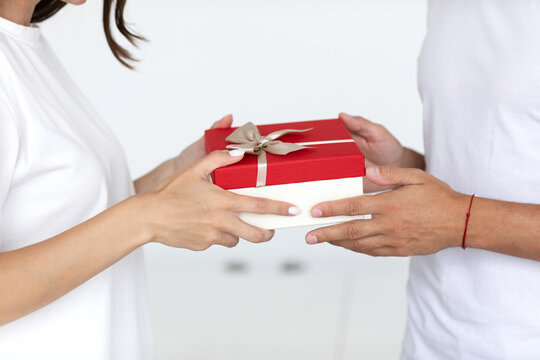 Close up man hands give wrapped gift box woman.