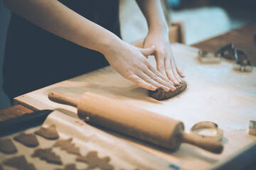 Woman preparing dough for Christmas or New Year party cookies at home ( cinematic color grading)