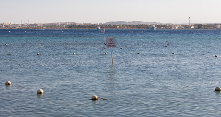 sign no entry coral area in red sea. buoy-fenced coral reef ecosystem. protected area
