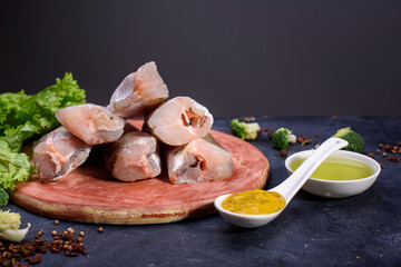 Fresh fish notation on a wooden board, with olive oil, sauce, spices, fresh lettuce leaves. Useful...