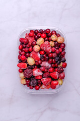 Frozen berry mix in a plastic container