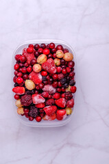 Frozen berry mix in a plastic container