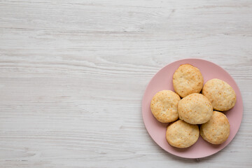 Homemade Flaky Buttermilk Biscuits on a pink plate on a white wooden background, top view. Flat lay, overhead, from above.