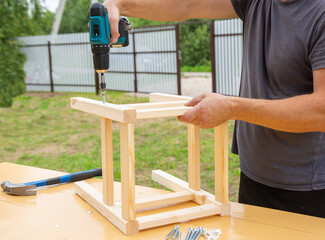 assembling a wooden stool with an electric screwdriver