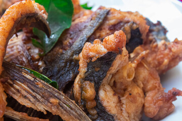 Lao Homemade Fried Fish on plate with Kaffir lime leaves, Close-up