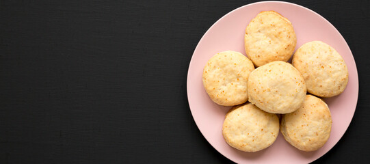 Homemade Flaky Buttermilk Biscuits on a pink plate on a black surface, top view. Flat lay, overhead, from above. Copy space.