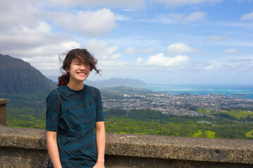 Teen girl looking at view of Oahu from Pali Lookout