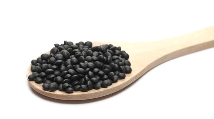 Black beluga lentils pile with wooden spoon isolated on white background