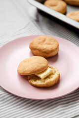 Homemade Flaky Buttermilk Biscuit on a pink plate on cloth, low angle view. Close-up.