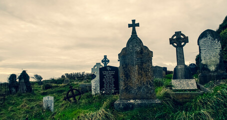 Ireland celtic cross at medieval church cemetery Old spooky cemetery . Haunted cemetery. Scary place. Old graves	