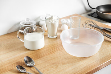eggs, flour a decanter with milk on the table and a whisk, the main background of baking. Home...