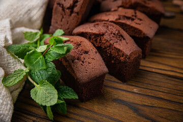Chocolate cupcakes with mint, cocoa, and cocoa beans on a wooden table
