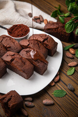 Chocolate cupcakes with mint, cocoa, and cocoa beans on a wooden table
