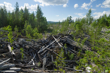 Fototapeta na wymiar The ruins of an old mine for the extraction of mica in the forest in Karelia