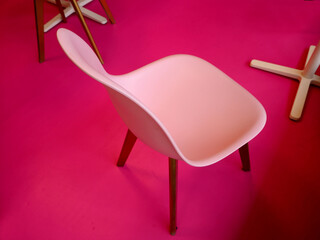 a pink plastic chair with a back sits on a bright pink floor covering