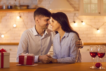 Man and a woman holding hands tenderly and lovingly looking into each other's happy eyes.