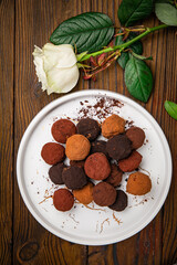 Truffle candies sprinkled with colorful cocoa on a plate
