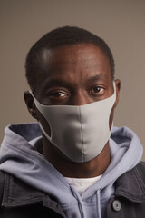 Close-up of African young man posing at camera in protective mask