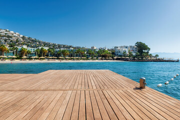 Wooden floor on a sea pier and beautiful beach resort on Mediterranean sea