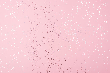 Feminine glamorous pastel color pink background with white shiny confetti