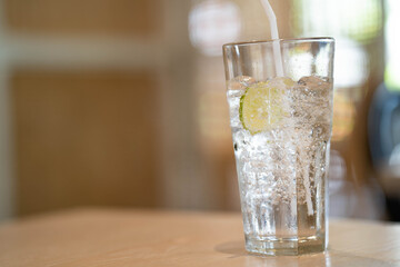 Sparkling water in glass on wooden table.
