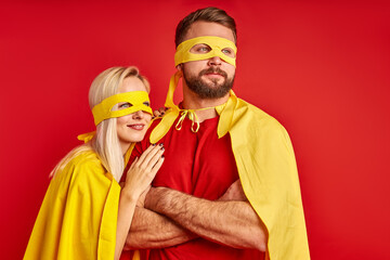 couple being superheroes, hope for success and leadership. caucasian man and woman in masks looking...
