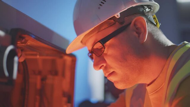 Engineer or electrician works with broken industrial robot cabinet using electrical tester