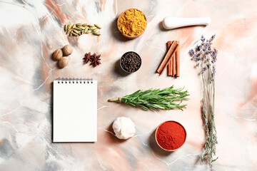 Notebook with spices on light background