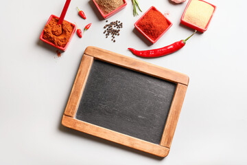 Chalkboard with various spices on light background