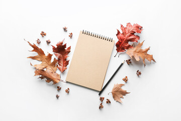 Beautiful autumn composition with leaves and notebook on white background