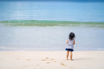 Fototapeta na wymiar Active little girl playing at sea shore in Phang Nga Thailand.