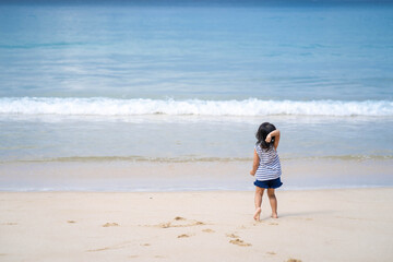 Active little girl playing at sea shore in Phang Nga Thailand.
