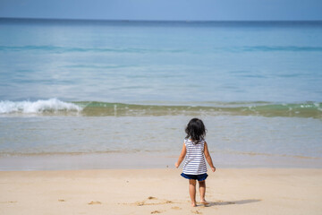 Fototapeta na wymiar Active little girl playing at sea shore in Phang Nga Thailand.