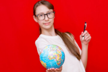 Close up teenager girl hold earth globe eyewear pen red studio background