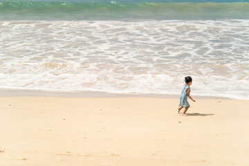 Active asian girl playing at sea shore in Phang Nga Thailand.