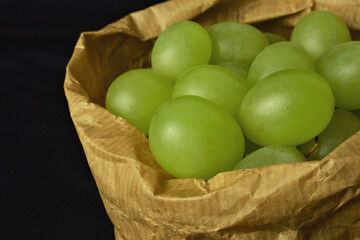 Bunch of grapes, close up. Inner kraft paper bag. Ecological. The grapes are also used to take on New Year's Eve, the well-known twelve grapes, in several Latin American countries and also in Spain.