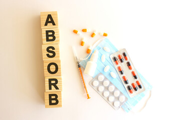 The word ABSORB is made of wooden cubes on a white background. Medical concept.