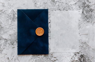 Blue velvet envelope with transparent paper on a blue background. Place for text.