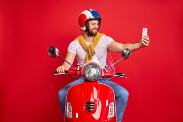 side view on young pleasant caucasian man taking photo of himself with bike, male in casual wear use smartphone on road, while driving