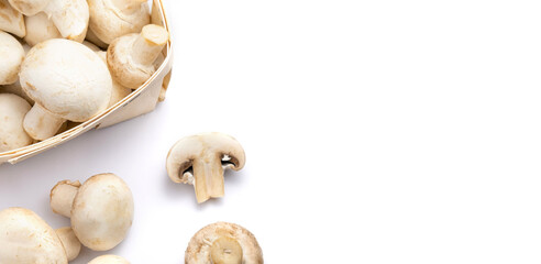 Fresh champignons in a basket isolated on white background.