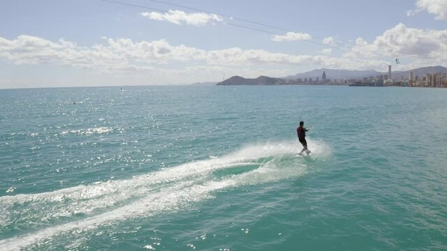 Aerial drone shot following a solo wakeboarder in Benidorm, Spain