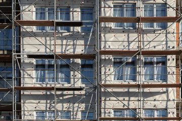 Fototapeta na wymiar Scaffolding for building insulation and finishing. The process of building a house, working with the facade. Abstract photography of the construction process.