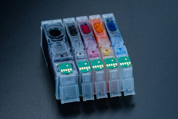 Cartridges / Tintenpatronen (mit Chip) von Tintenstrahldrucker stehen auf einem dunklen Hintergrund