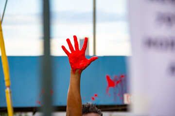 Mão pintada com tinta vermelha. Foto feita em manifestação contra o racismo na cidade de...