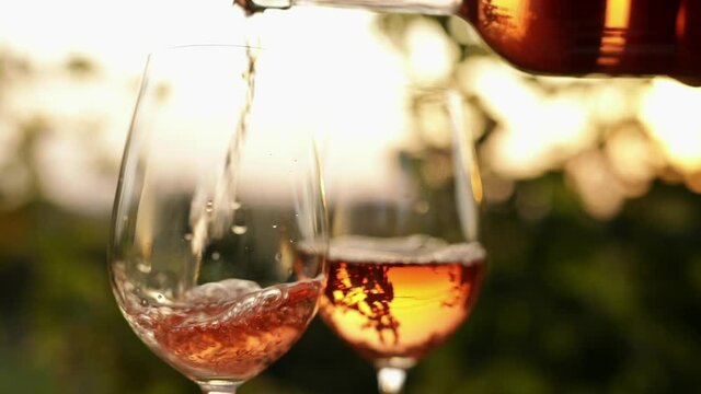 Pouring rose wine into glasses in the vineyard