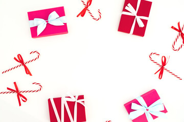 Christmas frame of gifts and candy cane on white background. Flat lay